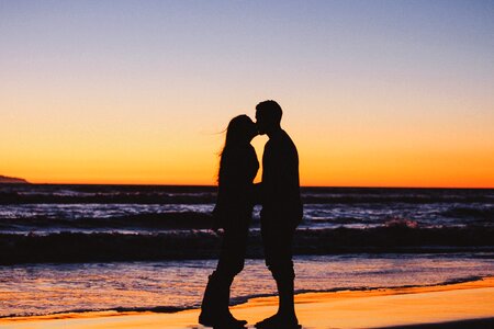 Sunset beach couple kiss photo