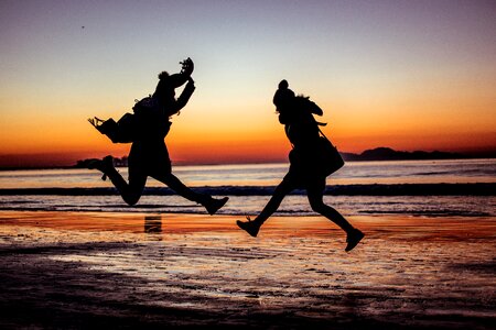 Sunset beach jump silhouette photo