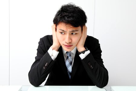 Business man cover ears