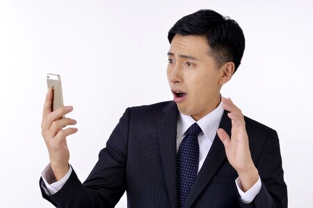 Business man smartphone shocked photo