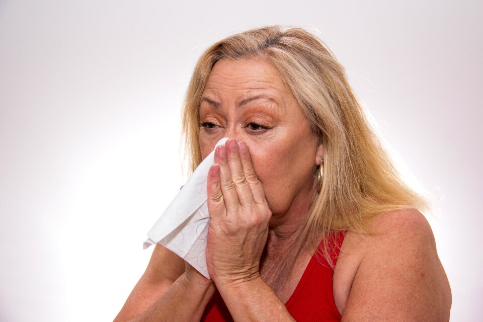 Senior woman blowing nose photo