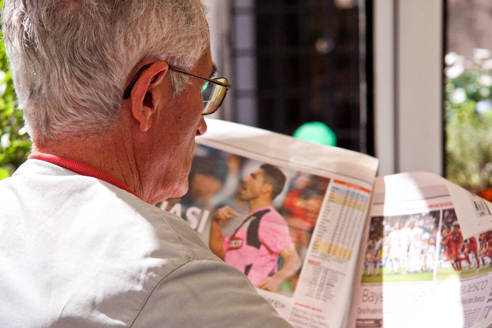 Old man reading newspaper