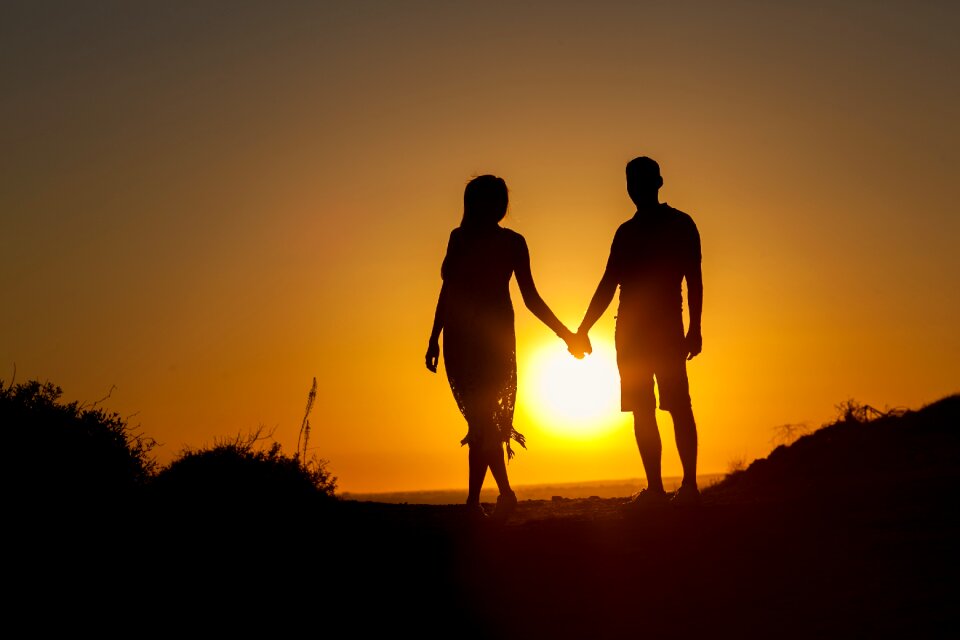 Sunset couple holding hands