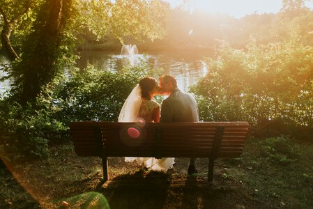 Bride groom kiss bench photo