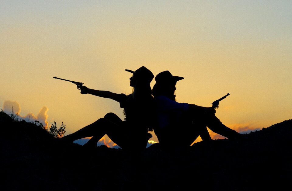 Cowgirls gun silhouette sunset