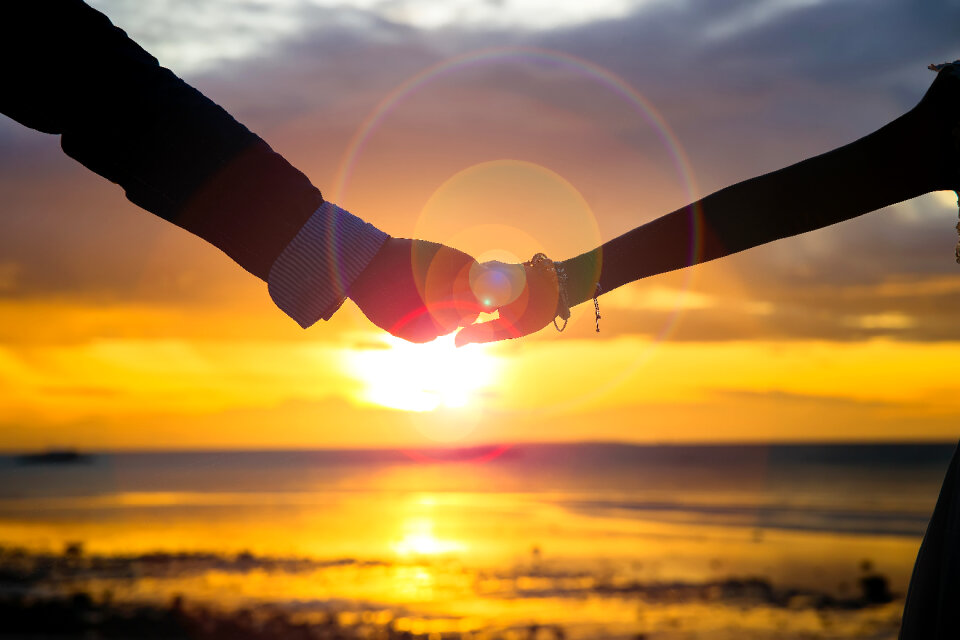 Sunset couple holding hands
