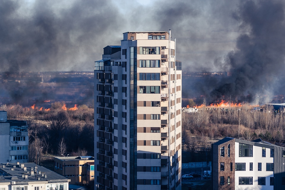 Apartments Tower With Field on Fire in Background