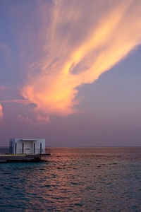 Bungalow on Water with Sunset Sky Behind photo