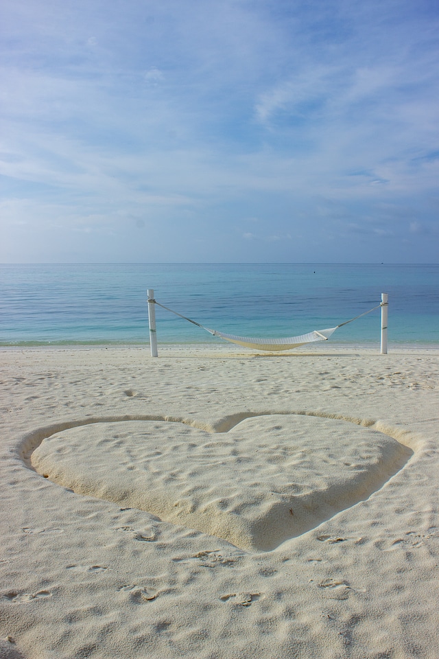 Heart Drawn in the Sand Next to a Hammock on a Beach