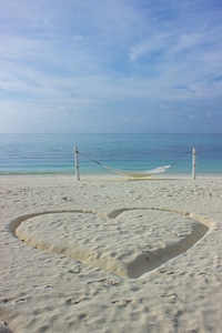 Heart Drawn in the Sand Next to a Hammock on a Beach photo