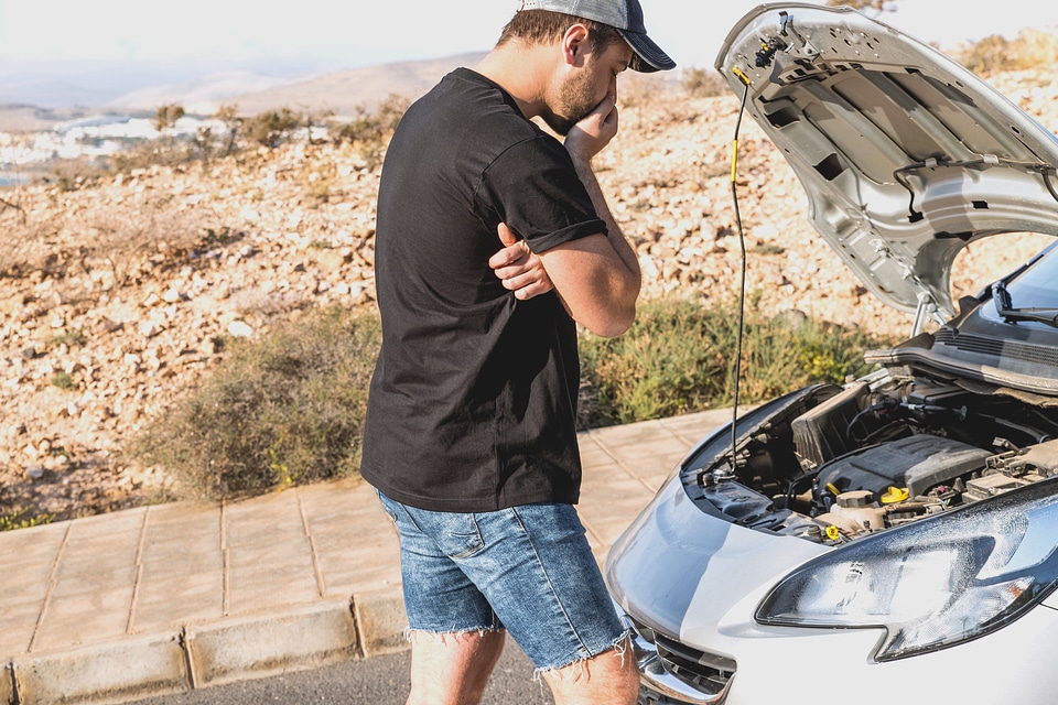 Man looking at engine of car photo