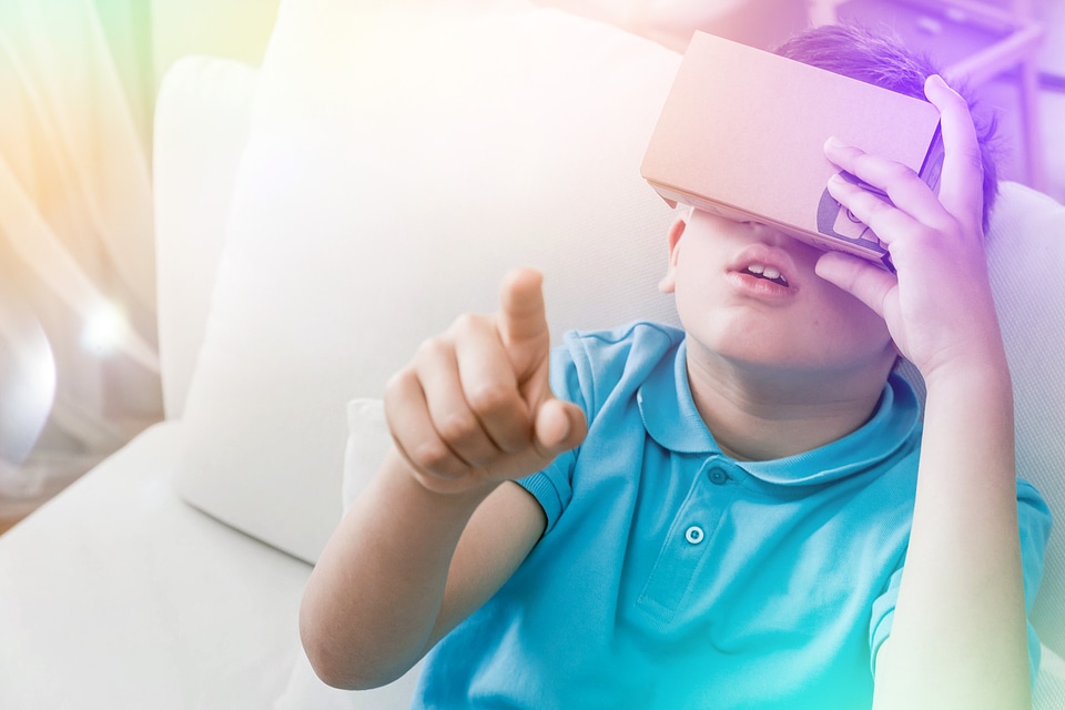 2 Amazed teen boy wearing virtual reality goggles watching movies or playing video games.