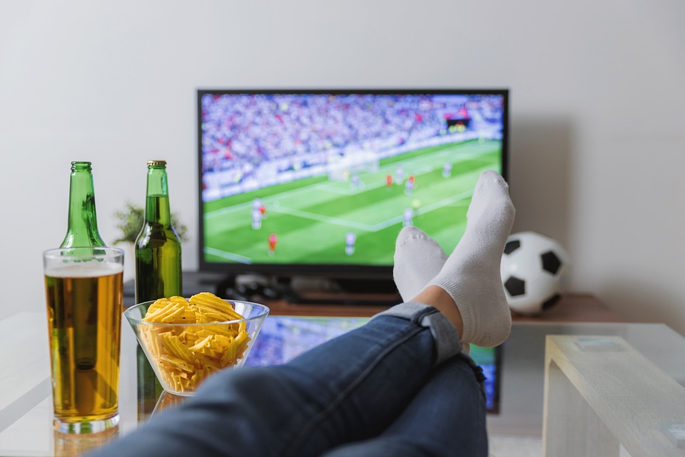 Watching a soccer match on TV with the feet on the table.