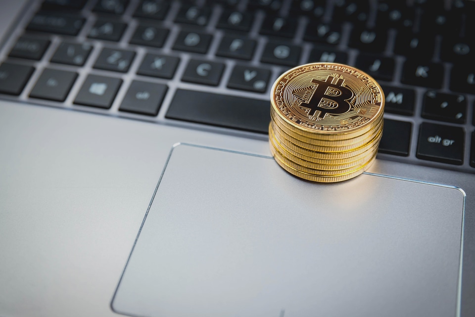 1 Golden Bitcoins on keyboard of metal laptop
