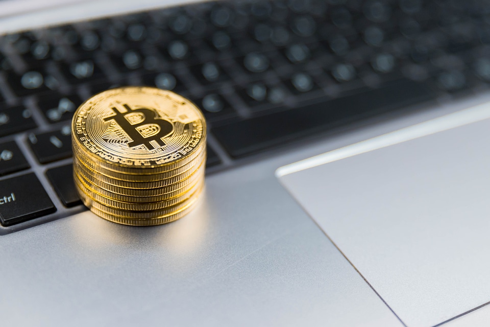 2 Golden Bitcoins on keyboard of metal laptop