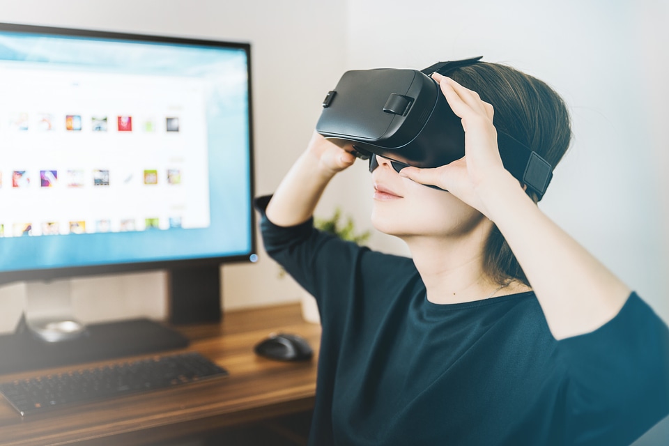 2 Woman wearing virtual reality goggles in her modern studio