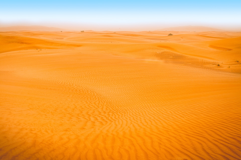 Desert landscape with blue sky. Dunes background