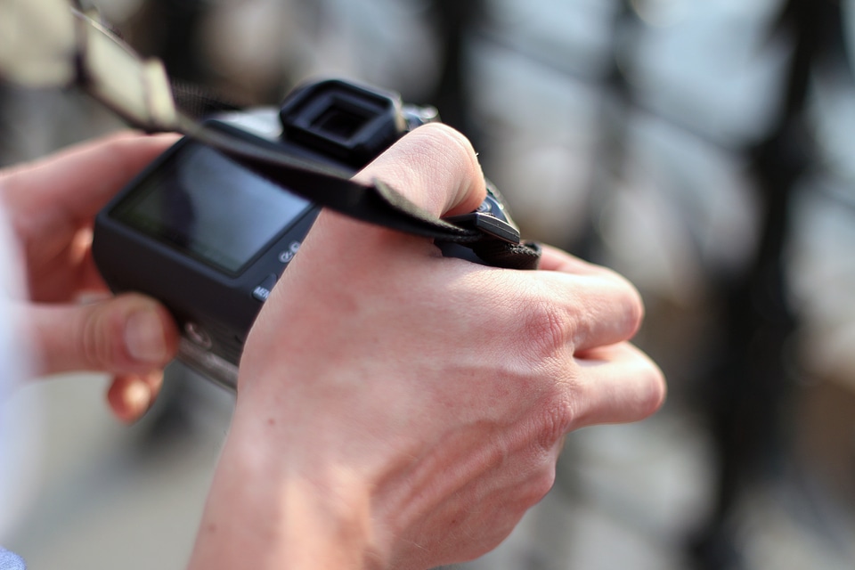 DSLR camera in photographer’s hands outdoors