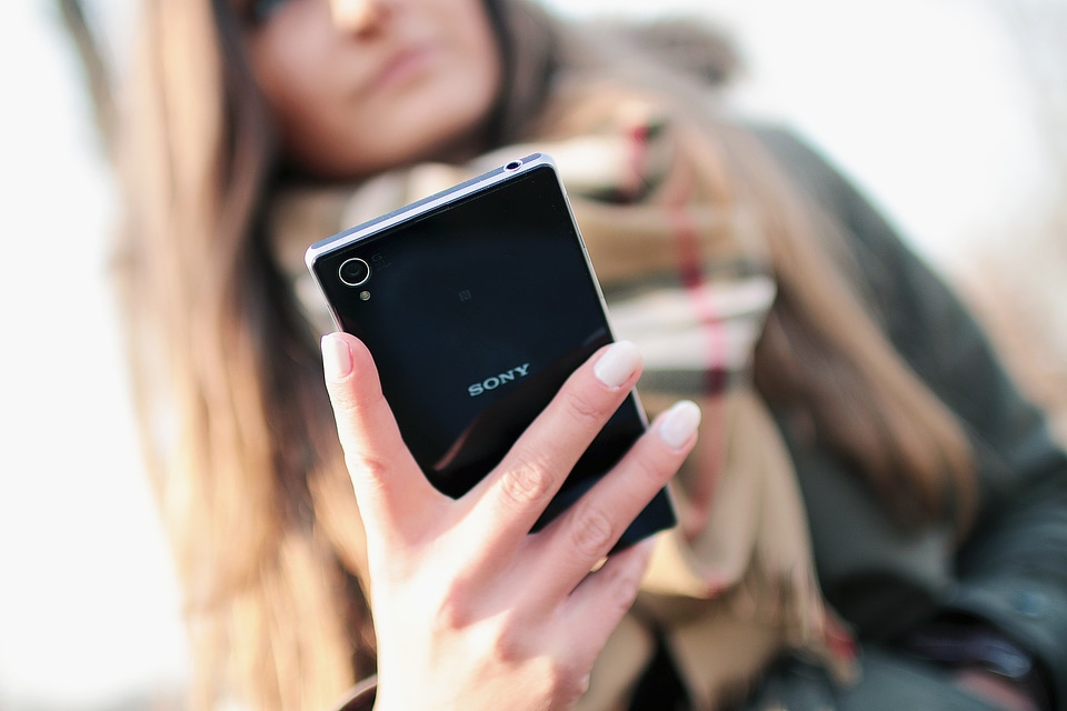 Back black luxury smartphone in hand modern woman