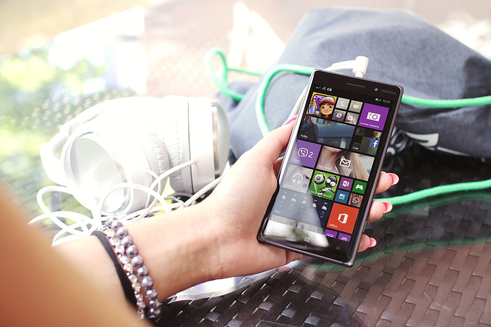 Modern smartphone in hand over glass table