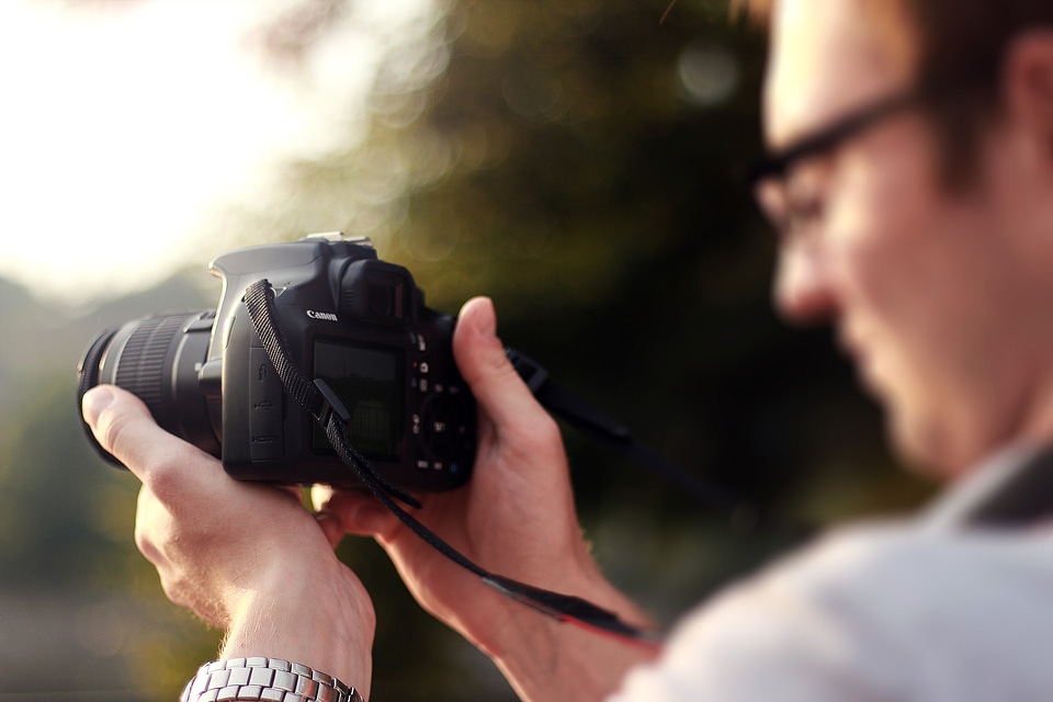 Young photographer using a DSLR in the city when is sunset
