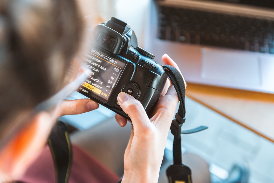 Photographer working on his DSLR camera in the cafe photo