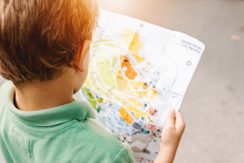 Small boy looking in to the map at amusement park