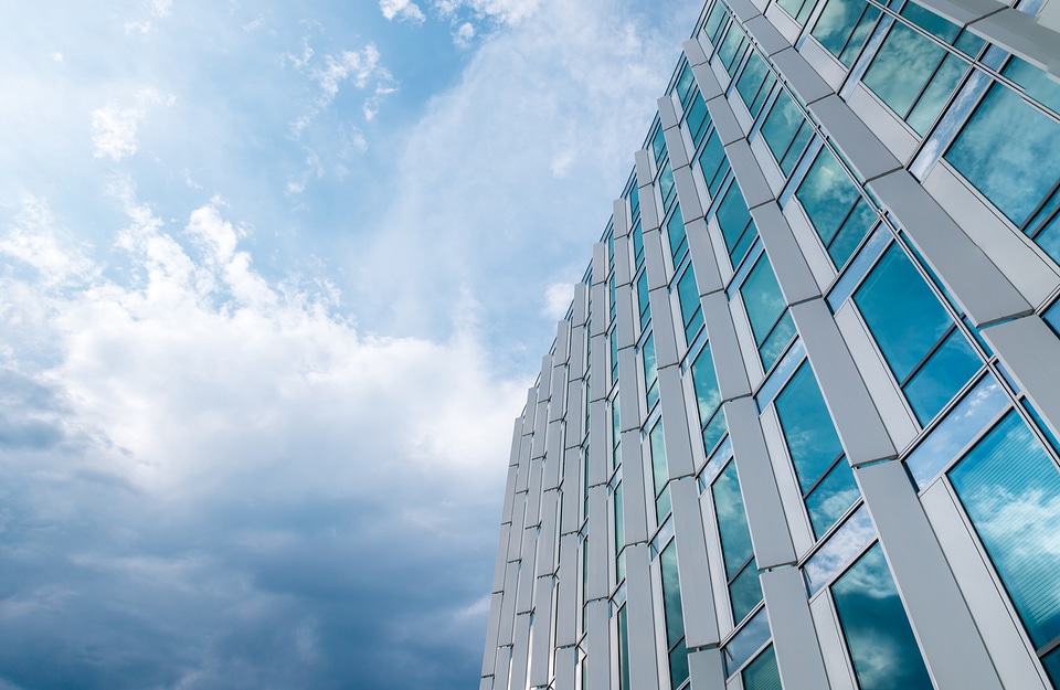 Amazing office building with windows. Blue sky with clouds after rain