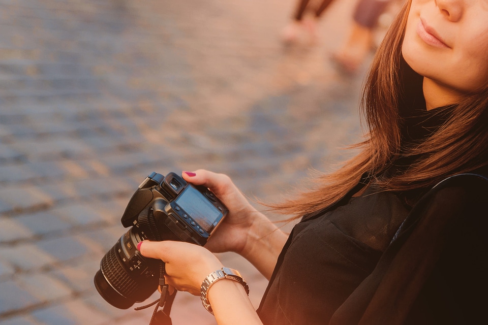Young photographer woman doing a photo in the city