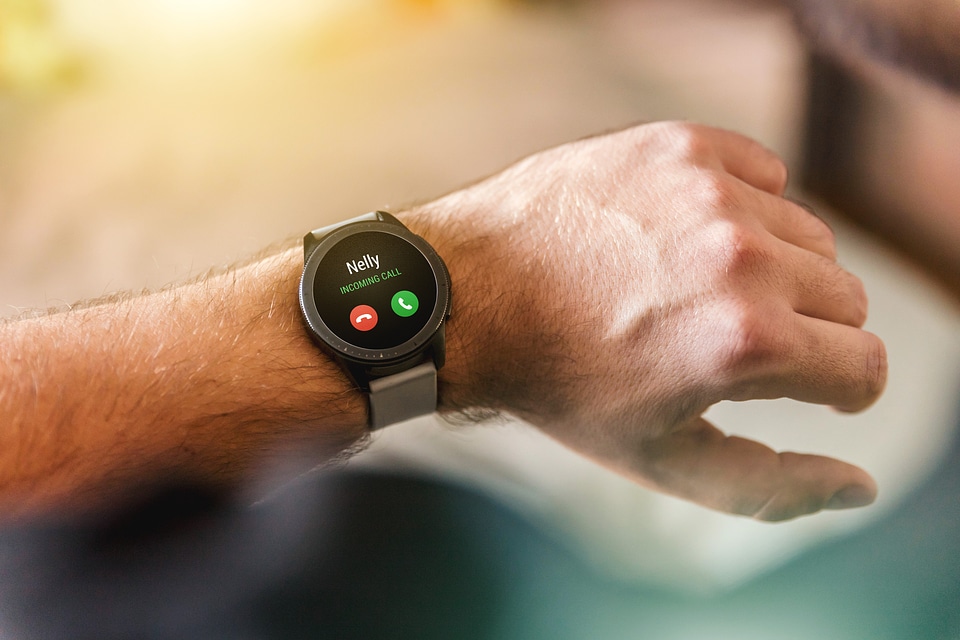 Male hand with black smartwatch with incoming call on display