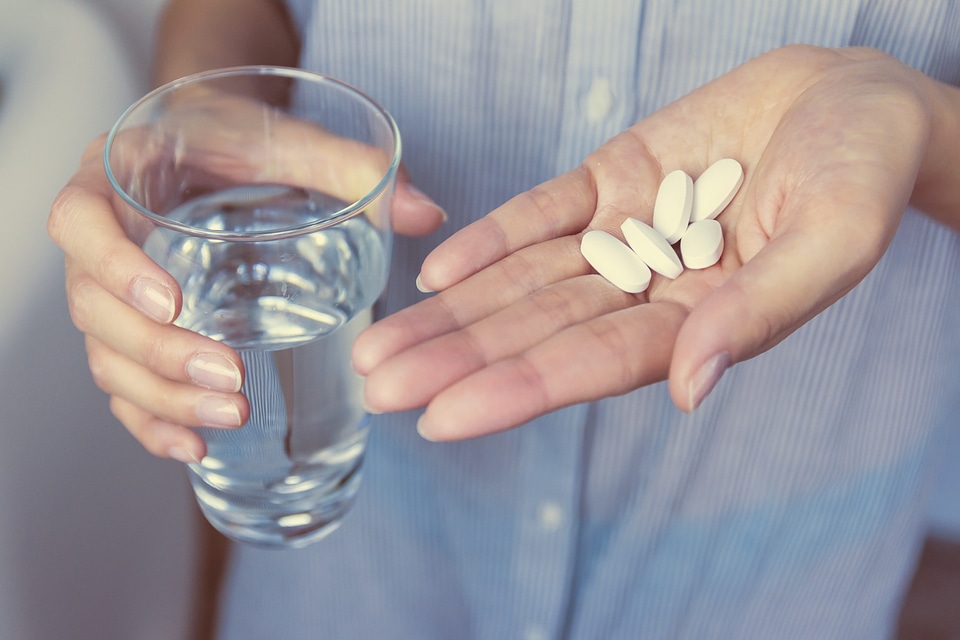 2 Hands of girl holding pills