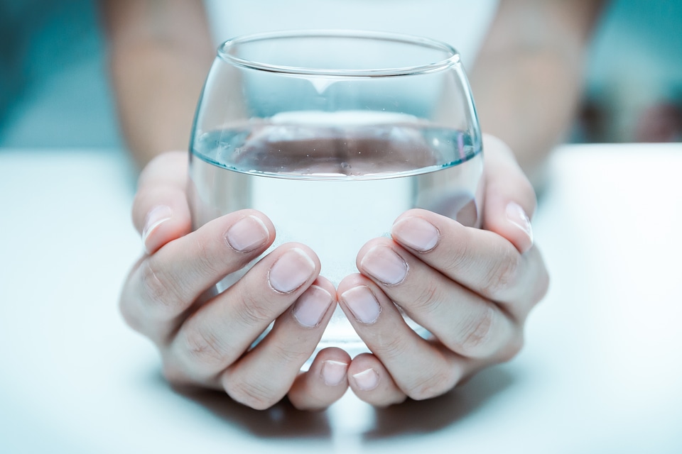 Female hand holding a glass of clean water, close-up. photo