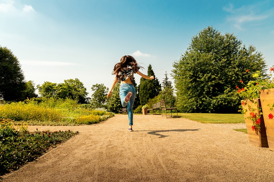 Happy young girl jump in park at summer