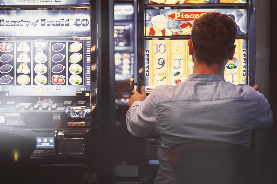 2 Man playing the slot machine at casino