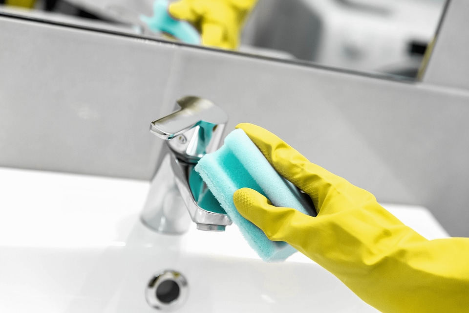Woman doing chores in bathroom, cleaning of water tap