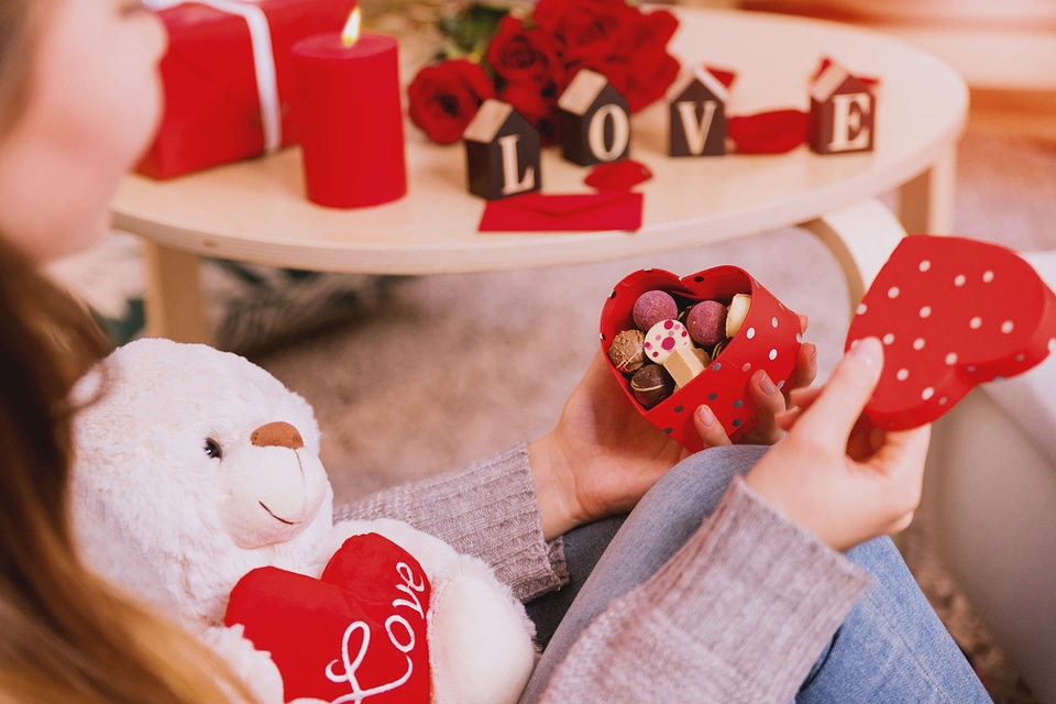 Happy and joyful young woman holding heart box with candies. Happy Valentine’s Day.