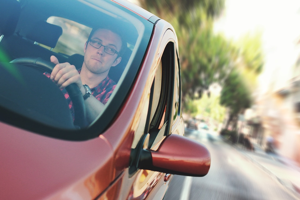 Detail on the young driver inside in car in motion