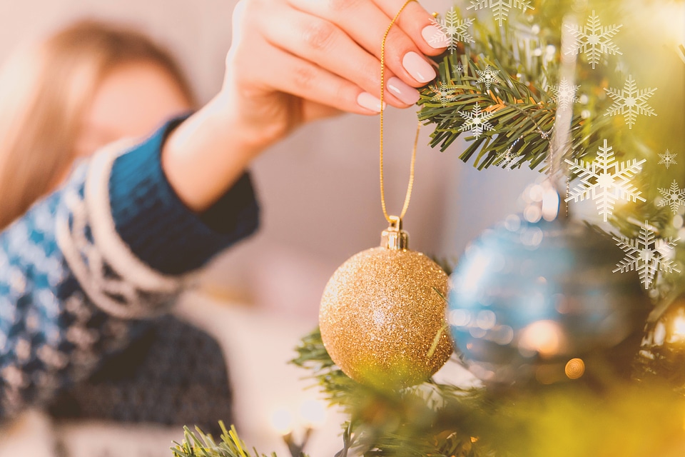1 Woman decorating Christmas tree with baubles