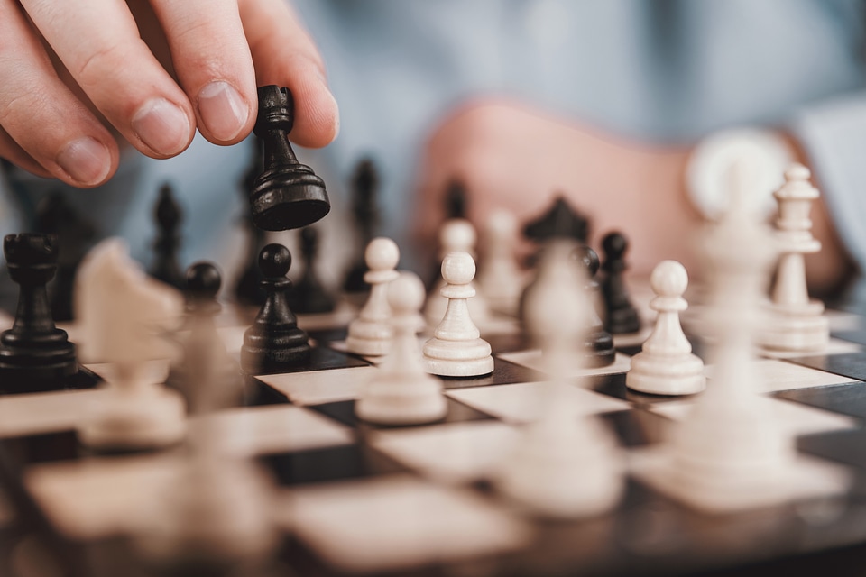 1 Young businessman playing chess in the office