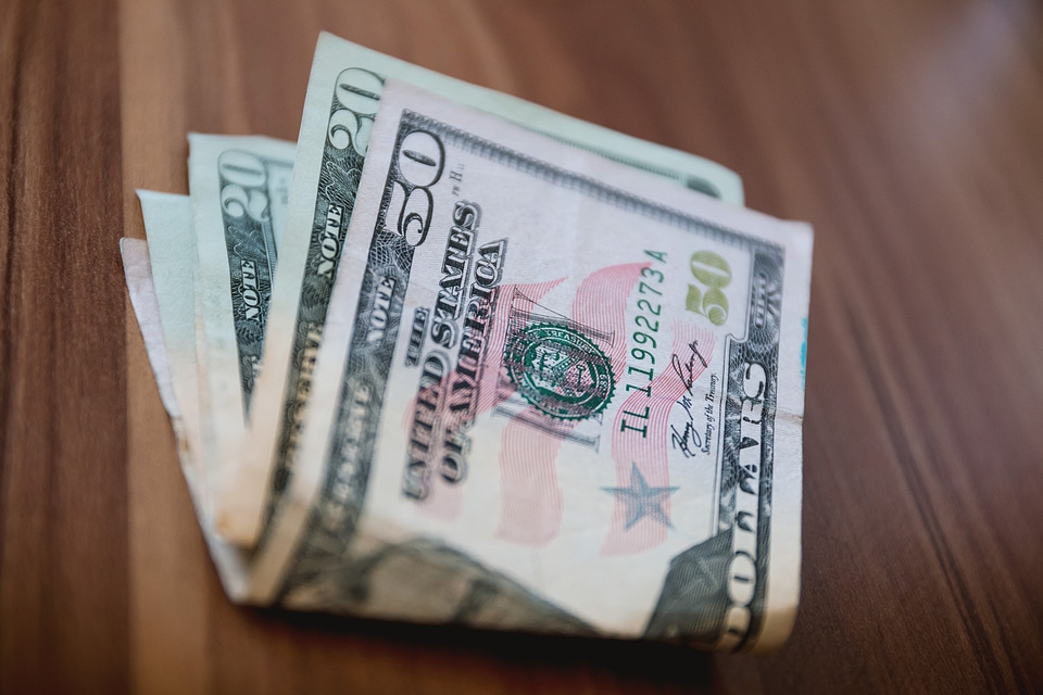 A few American dollars on the wooden table