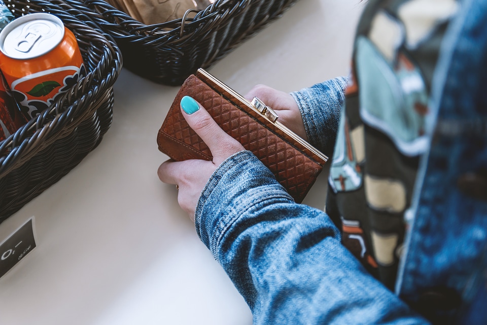 Woman at the checkout with her fashion wallet in hand
