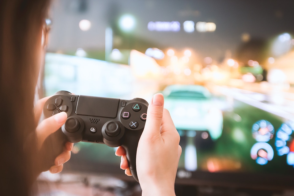 Young girl with gamepad playing games on TV