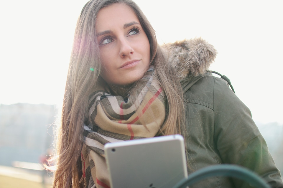 Nice girl looks around and has a tablet in hand