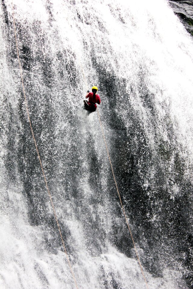 Rappelling abseiling gray waterfall