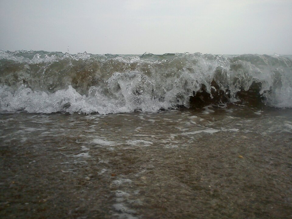 Wave breaking foam sand beach