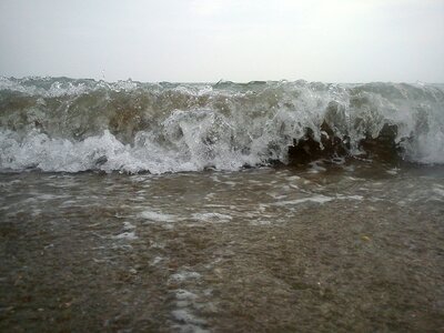 Wave breaking foam sand beach photo