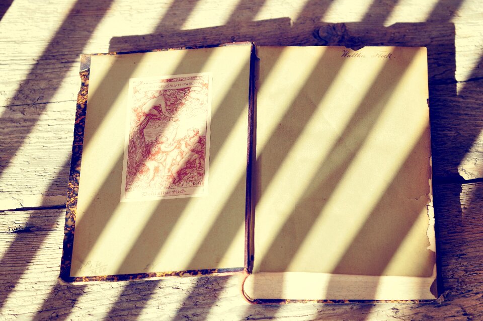 Book pages wooden table light and shadow
