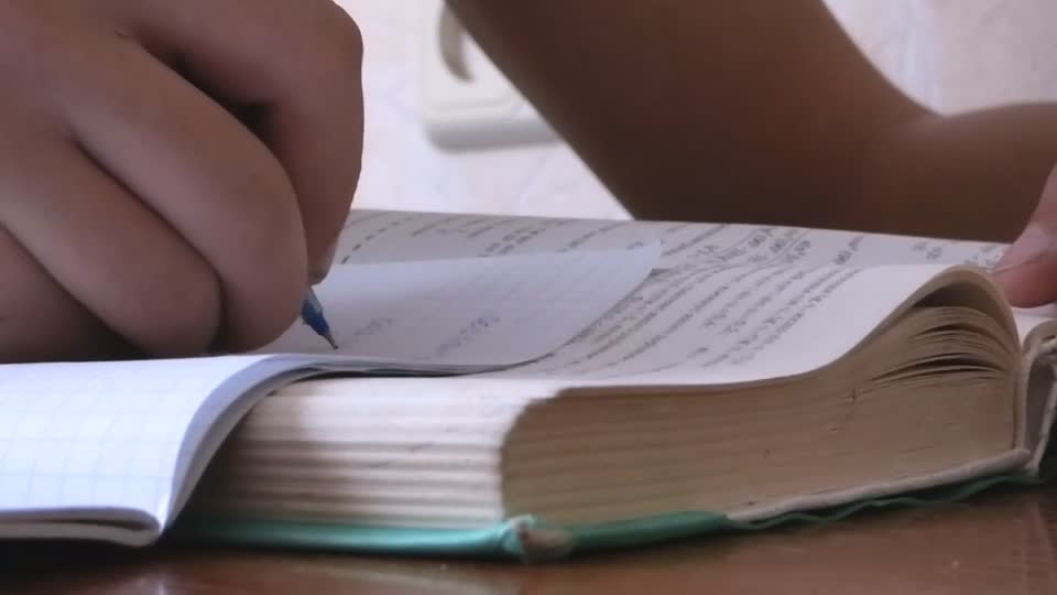 On the table lies a thick textbook homework textbook