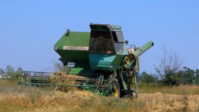 Harvester tractor in field harvests tractor