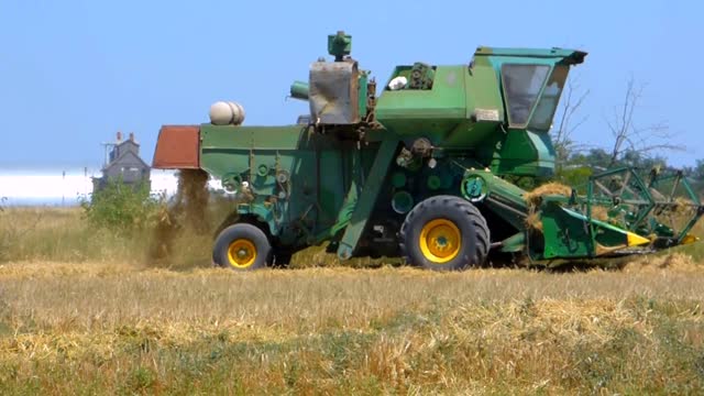 Harvester tractor in field harvests tractor